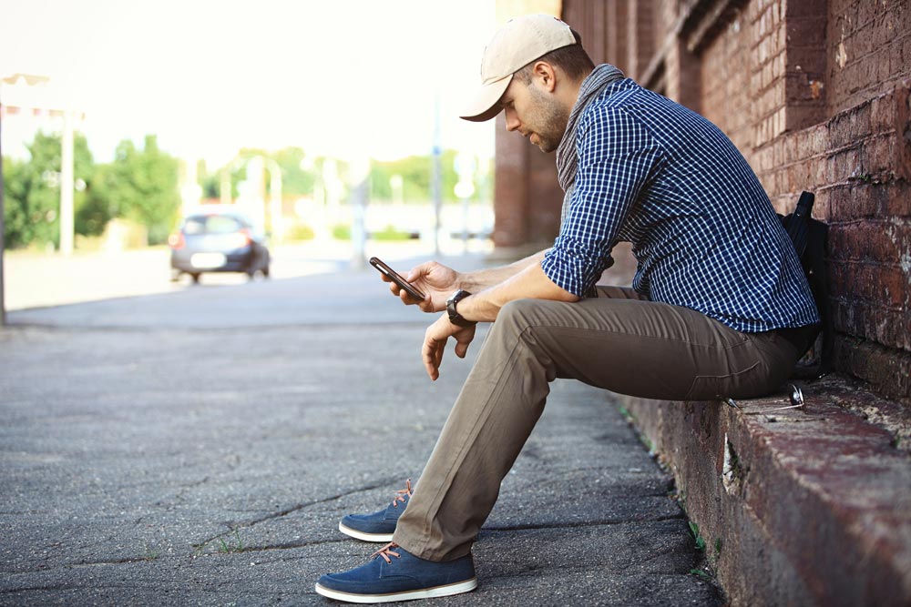 lagunashoresrecovery-Traveling-to-Rehab-–-Pros-and-Cons-photo-of-a-man-texting