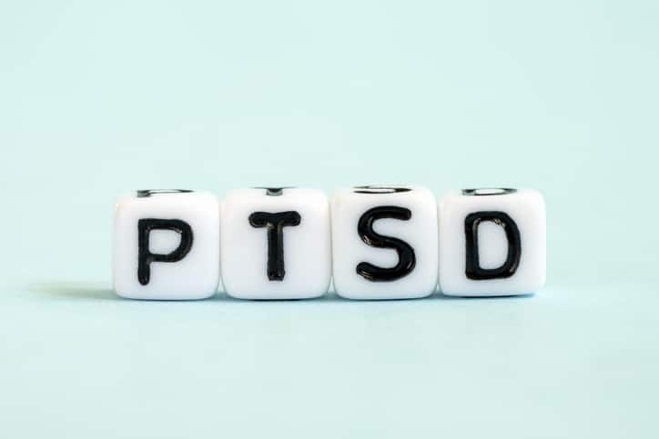 PTSD word written on blocks. Posttraumatic stress disorder inscription on blue background. Medical concept